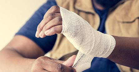 man bandaging his hand